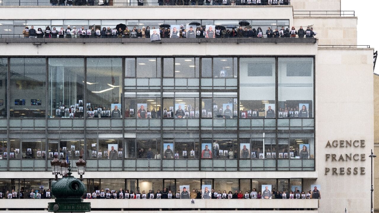 AFP journalists held up portraits of their colleagues in Gaza at the agency's Paris headquarters