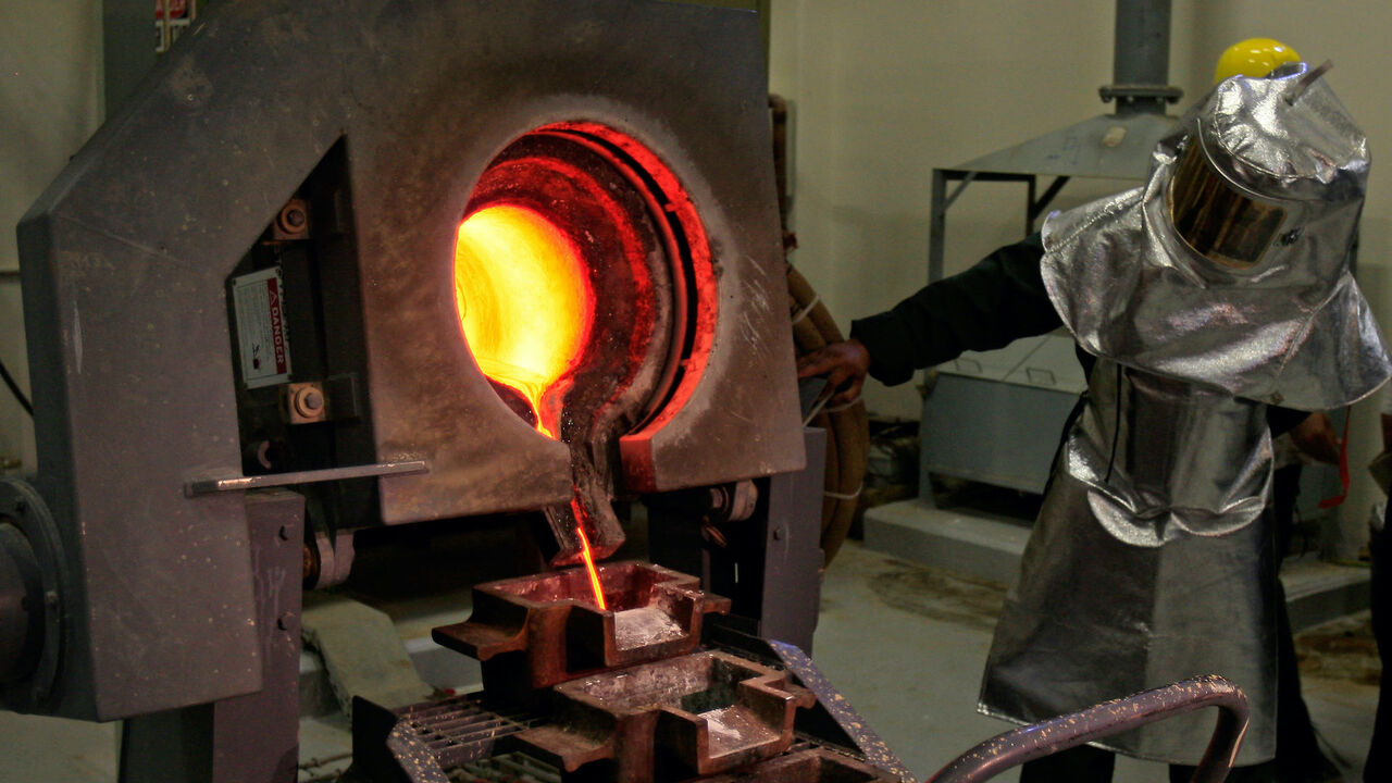 A Saudi mine worker pours a stream of molten gold from the furnace into moulds to produce gold ingots during a press tour at the Al-Amar Gold Mine, 195kms southwest of the Saudi capital Riyadh, on May 28, 2008.