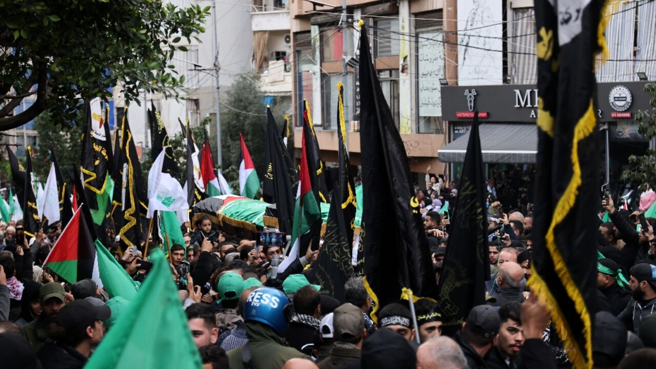 Crowds march in the Beirut funeral procession of Hamas number two Saleh al-Aruri killed along with six other Palestinian militants in a strike on the Lebanese capital blamed on Israel