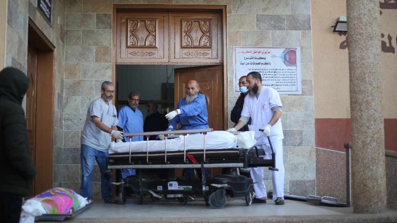 Doctors move a body ahead of prayers at Nasser hospital in Khan Yunis in December