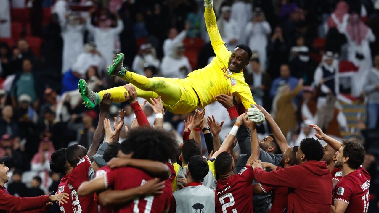 Qatar's players lift goalkeeper Meshaal Barsham into the air