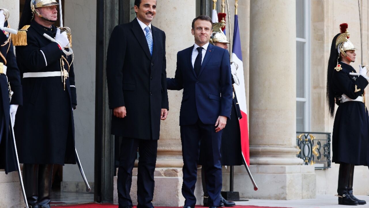 French President Emmanuel Macron greets Qatar's Emir Sheikh Tamim bin Hamad al-Thani at the Elysee Palace before talks dominated by the Gaza war