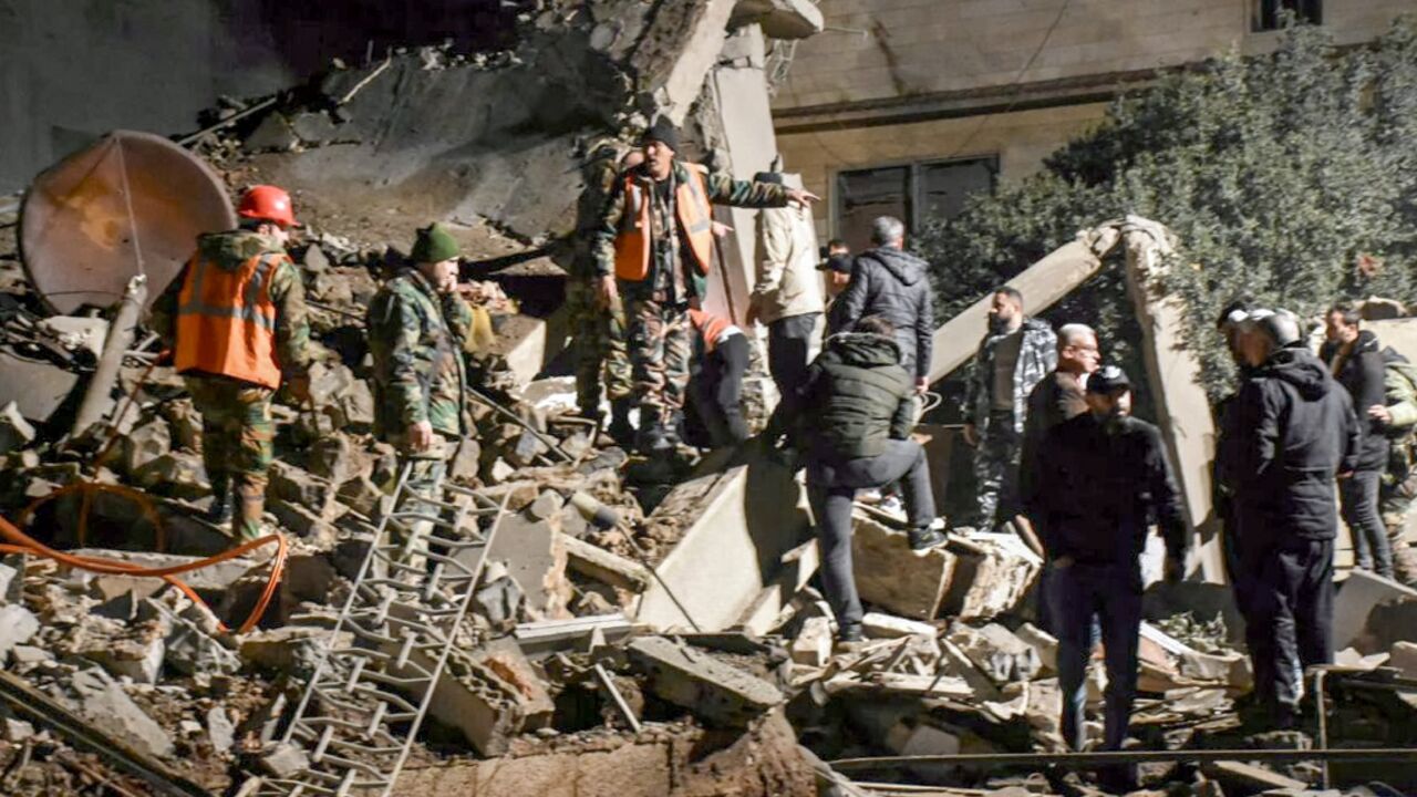 Emergency services search through the rubble of a building in the central Syrian city of Homs after it was flattened by an air strike the government blamed on Israel