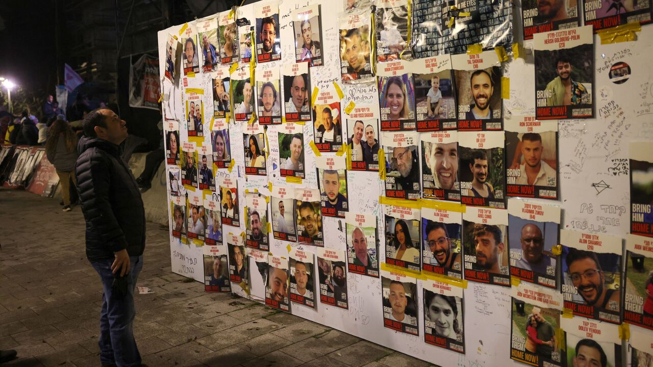 People look at portraits of Israeli hostages held in Gaza since the October 7 attacks by Palestinian Hamas militants, as relatives and supporters rally calling for their release in Tel Aviv on February 3, 2024.