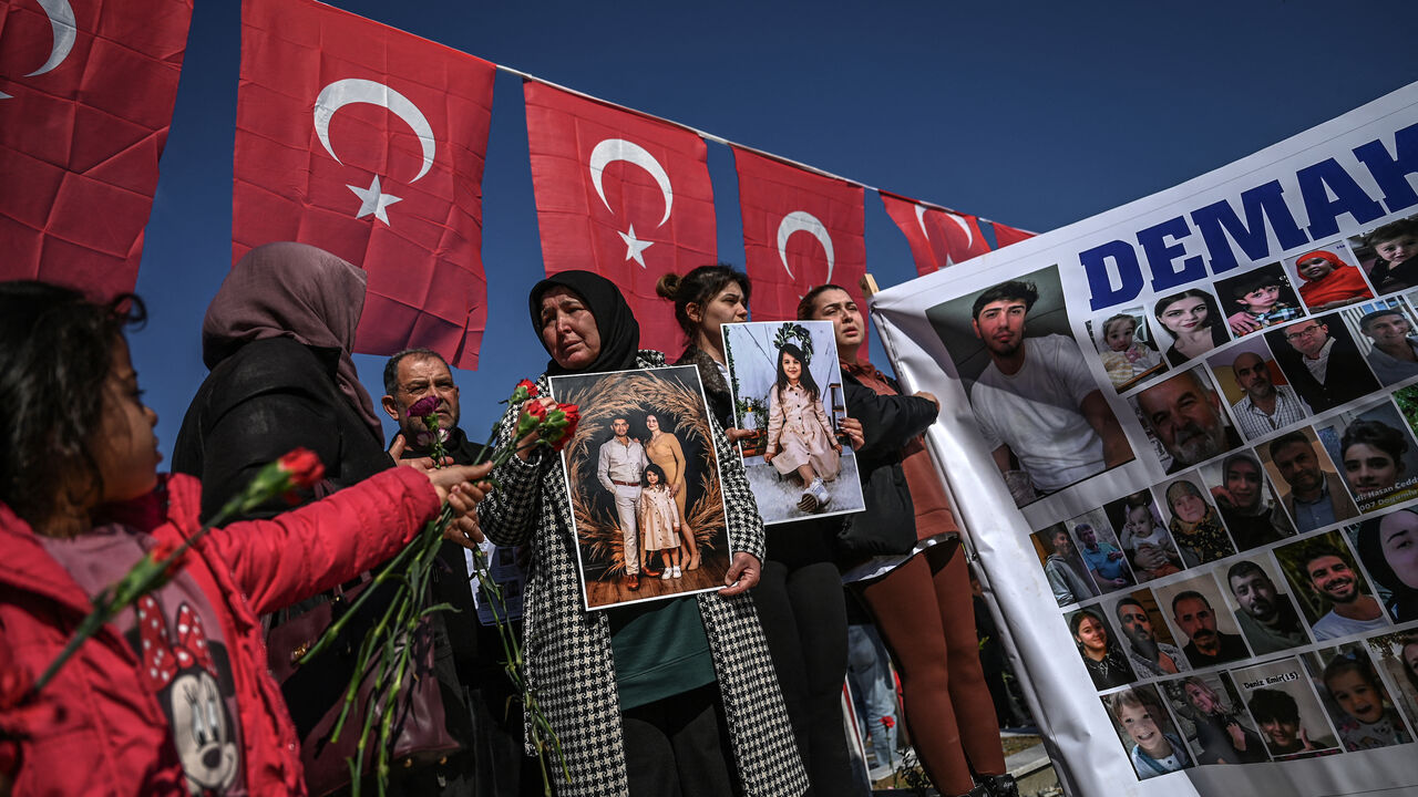 Relatives of missing persons hold placards and a banner with their portraits at the Hatay Earthquake Martyrs Cemetery, during a gathering marking the first anniversary of a powerful earthquake that hit the region, in Antakya, southern Turkish Hatay Province, on Feb. 6, 2024. 