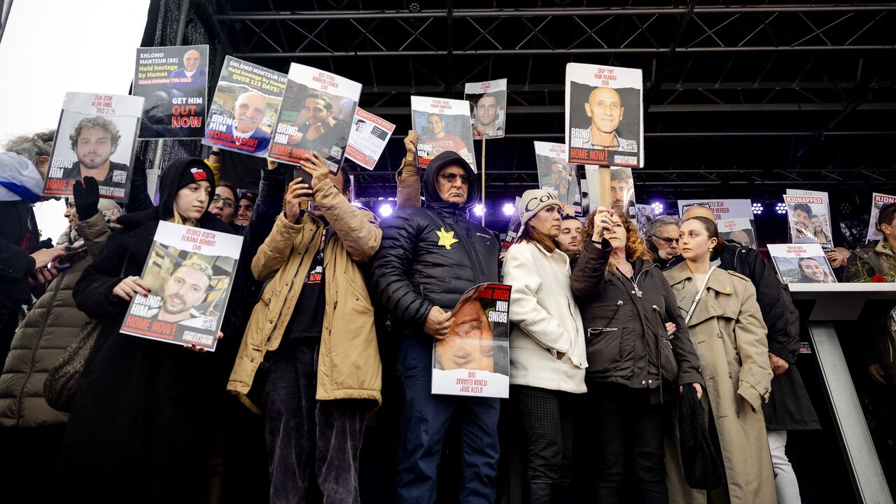 Representatives of Gaza Israeli hostages stand on a stage during a gathering outside the International Criminal Court (ICC).