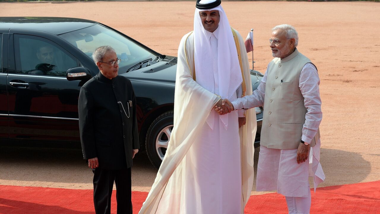 Indian President Pranab Mukherjee (L) watches as Indian Prime Minister Narendra Modi (R) shake hands with Emir of the State of Qatar Sheikh Tamim Bin Hamad Al-Thani (C) during a ceremonial reception in New Delhi on March 25, 2015.