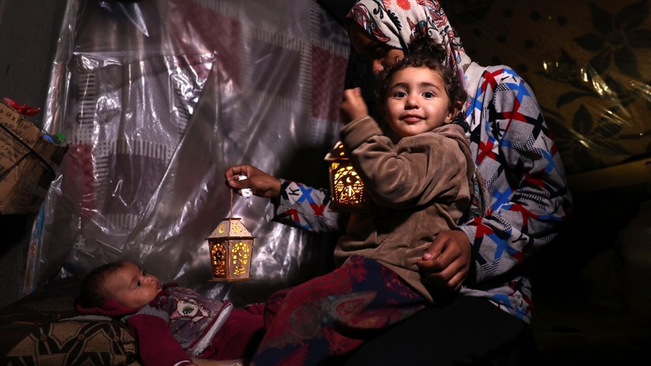 A Palestinian child plays with traditional fanous lanterns as Muslim devotees prepare for the start of the holy fasting month of Ramadan, in Rafah in the southern Gaza Strip 