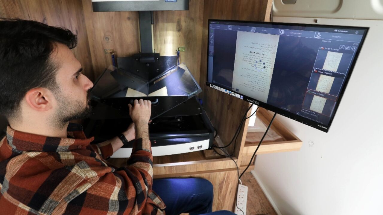 A member of the Kurdistan Centre for Arts and Culture in the Iraqi city of Dohuk scans the pages of a rare book, part of a project to digitise Kurdish literary and historical works