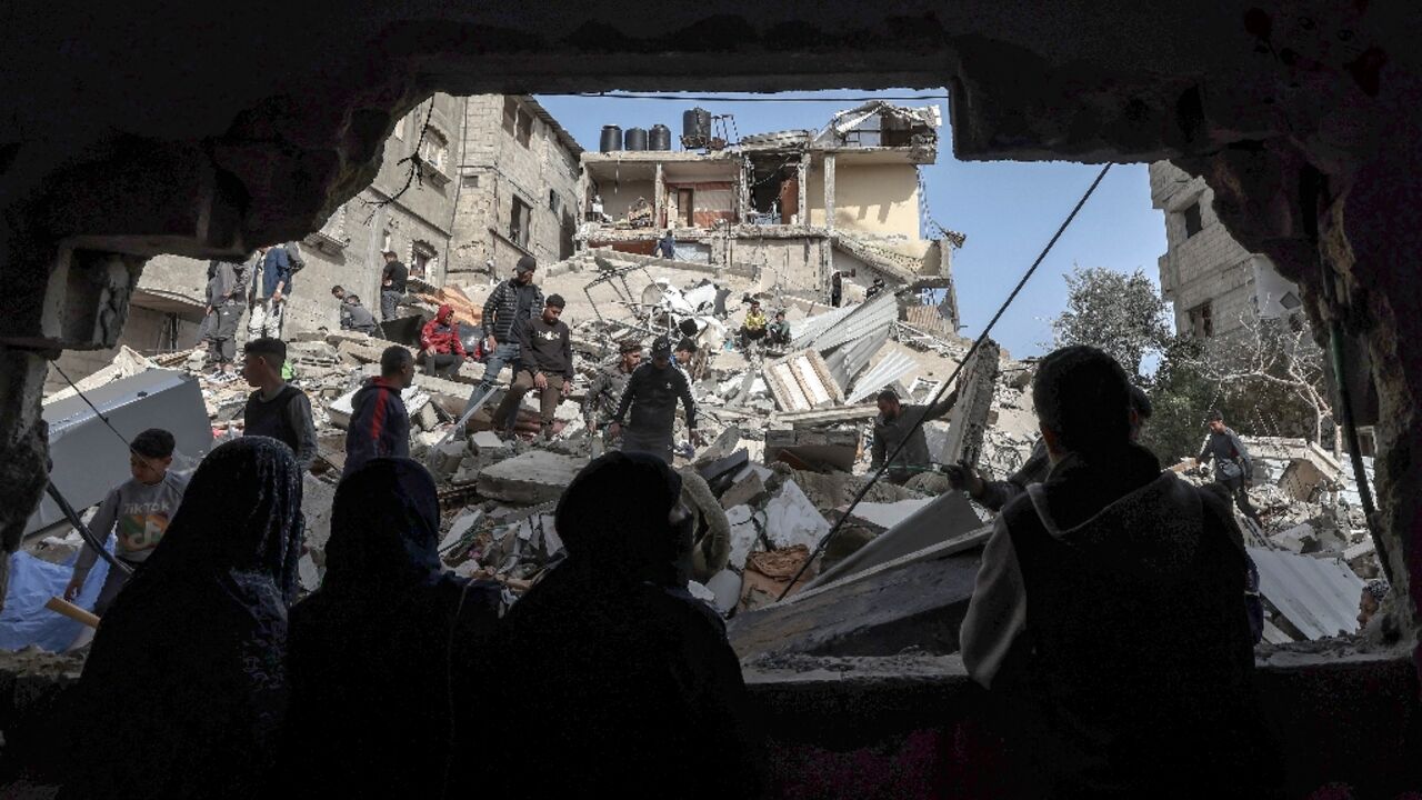 Palestinians check the rubble of buildings that were destroyed following overnight Israeli bombardment in Rafah, in the southern Gaza Strip