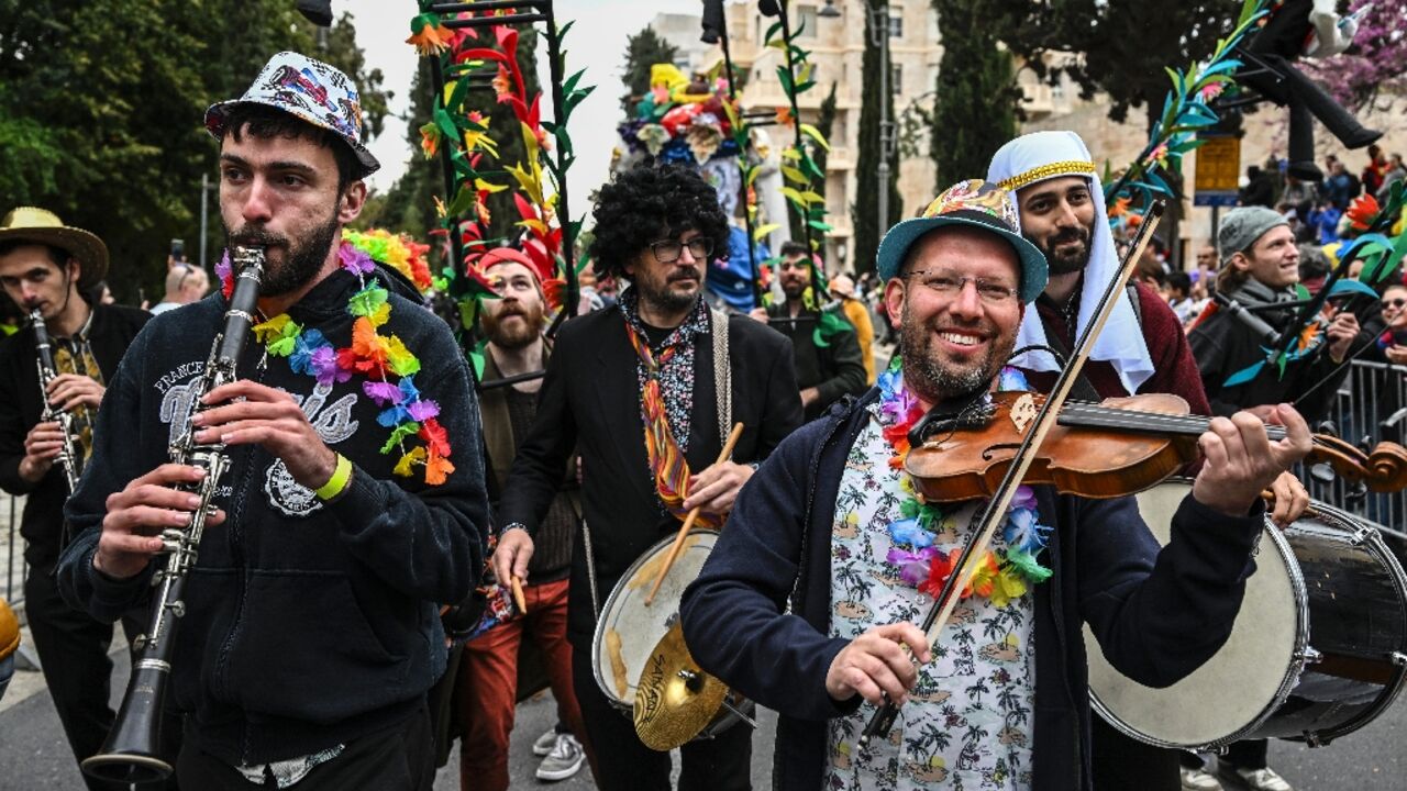 Smiling through: Musicians play during the subdued Purim parade through Jerusalem
