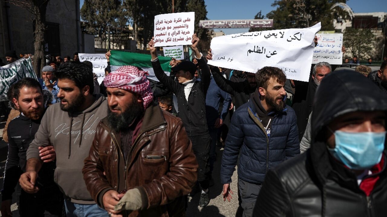 Protesters march through the Syrian city of Idlib in a rare protest against former Al-Qaeda affiliate Hayat Tahrir al-Sham (HTS), which controls much of the northwest of the country