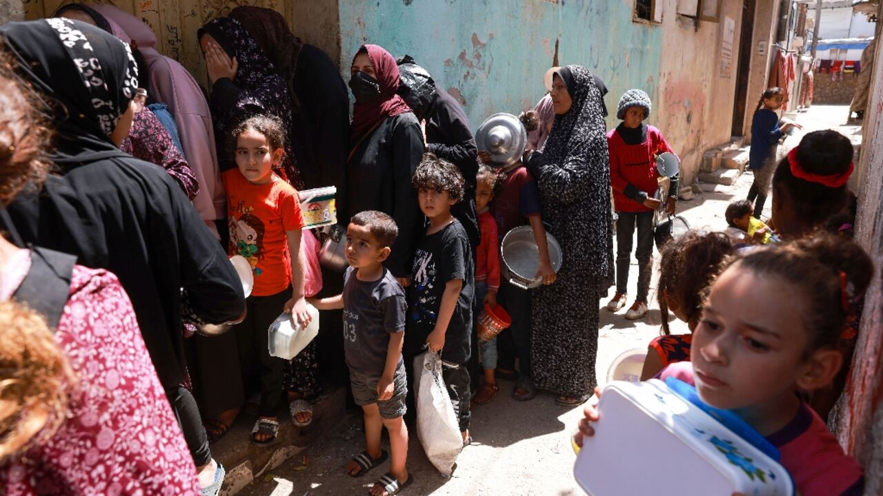 Displaced Palestinian children line up to receive food in Rafah