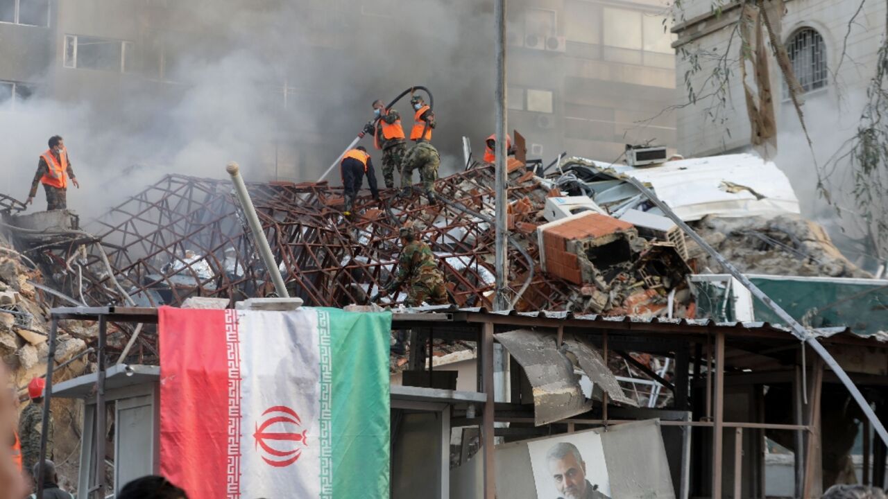 An Iranian flag is draped over the railings outside the flattened consular annex of the Iranian embassy in Damascus