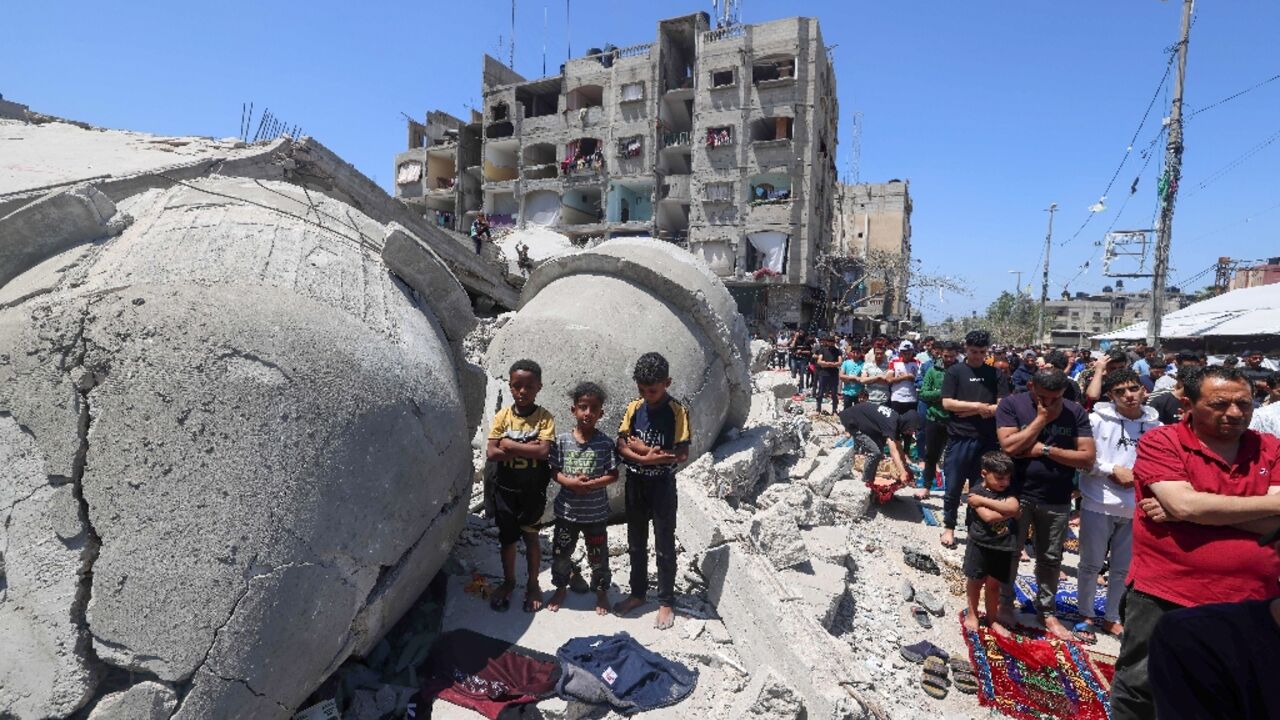 Palestinians pray next to the ruins of Al-Farooq Mosque, destroyed during Israeli bombardment in Rafah