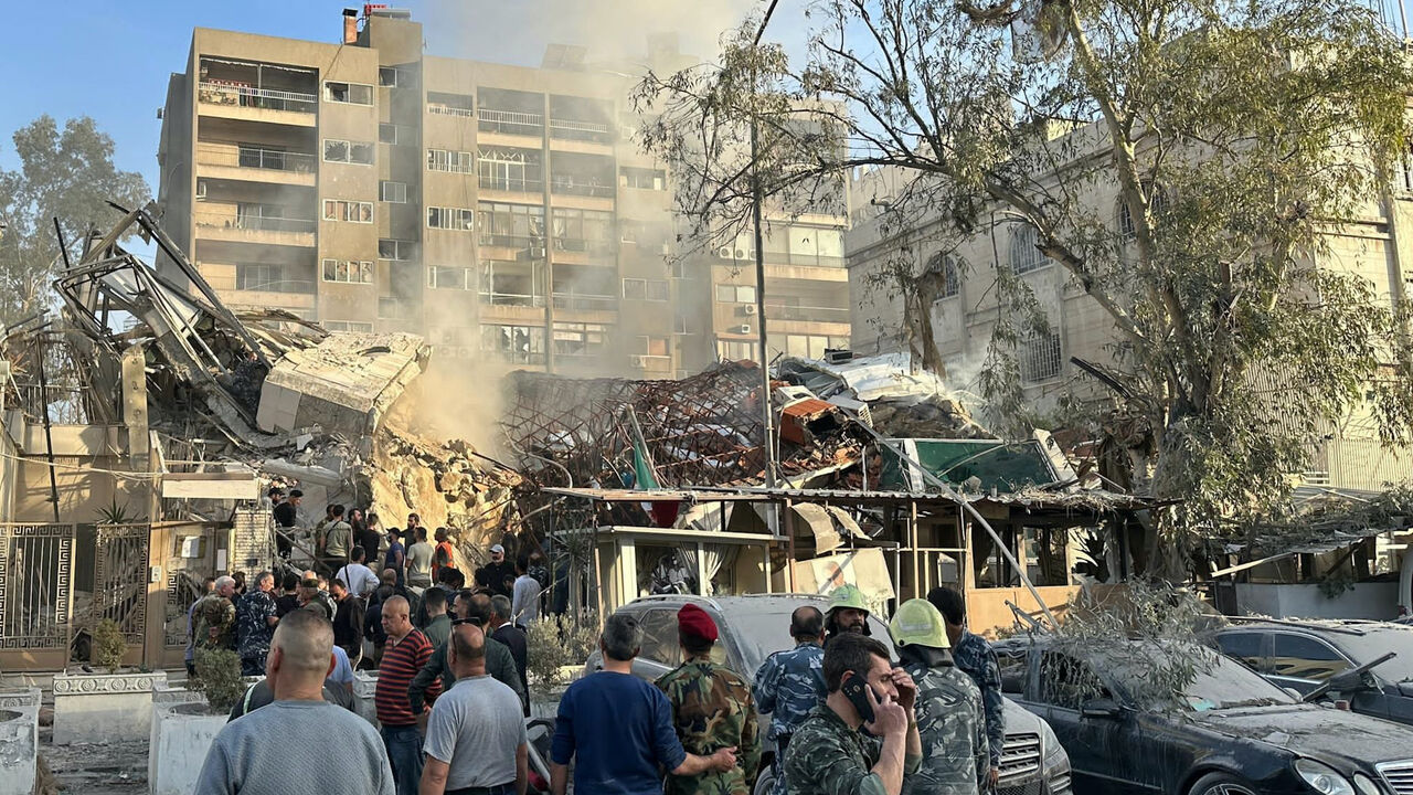 Emergency and security personnel gather at the site of strikes which hit a building next to the Iranian embassy in Syria's capital Damascus, on April 1, 2024. 