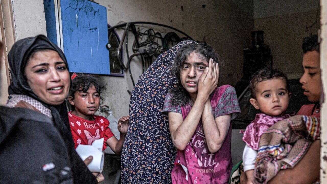 A woman and children react following Israeli bombardment in Nuseirat, central Gaza