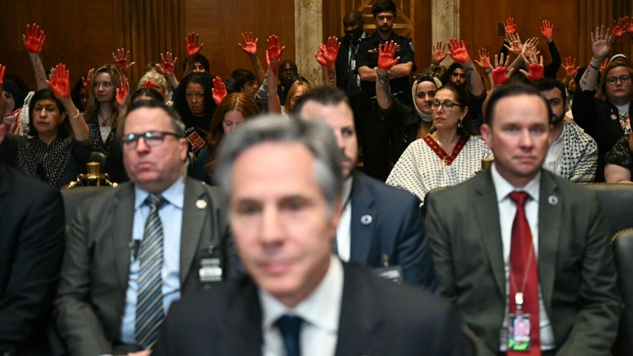 Pro-Palestinian demonstrators hold up painted hands in protest as US Secretary of State Antony Blinken testifies before a Senate Appropriations subcommittee 