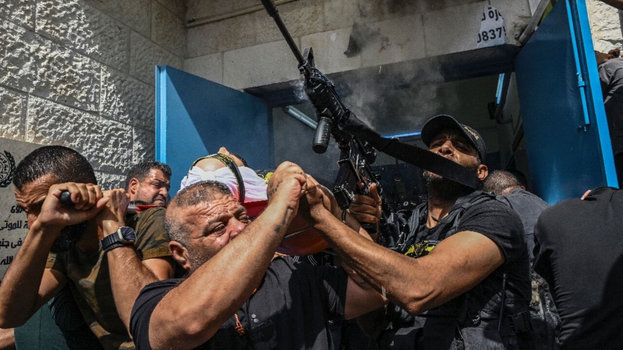 Several of the bodies were draped in flags and marched by crowds of Palestinians, including armed militants, through the streets