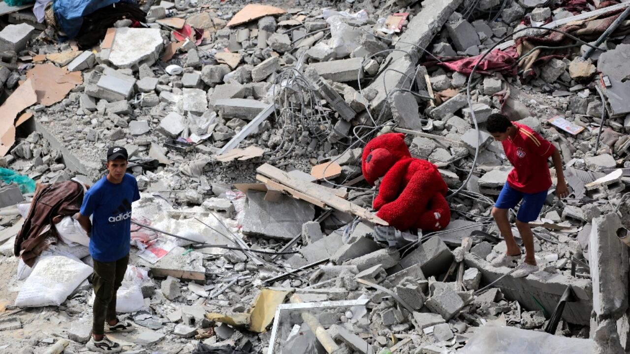 Palestinians inspect the rubble of a residential building destroyed by an Israeli strike on Al-Zawayda in central Gaza