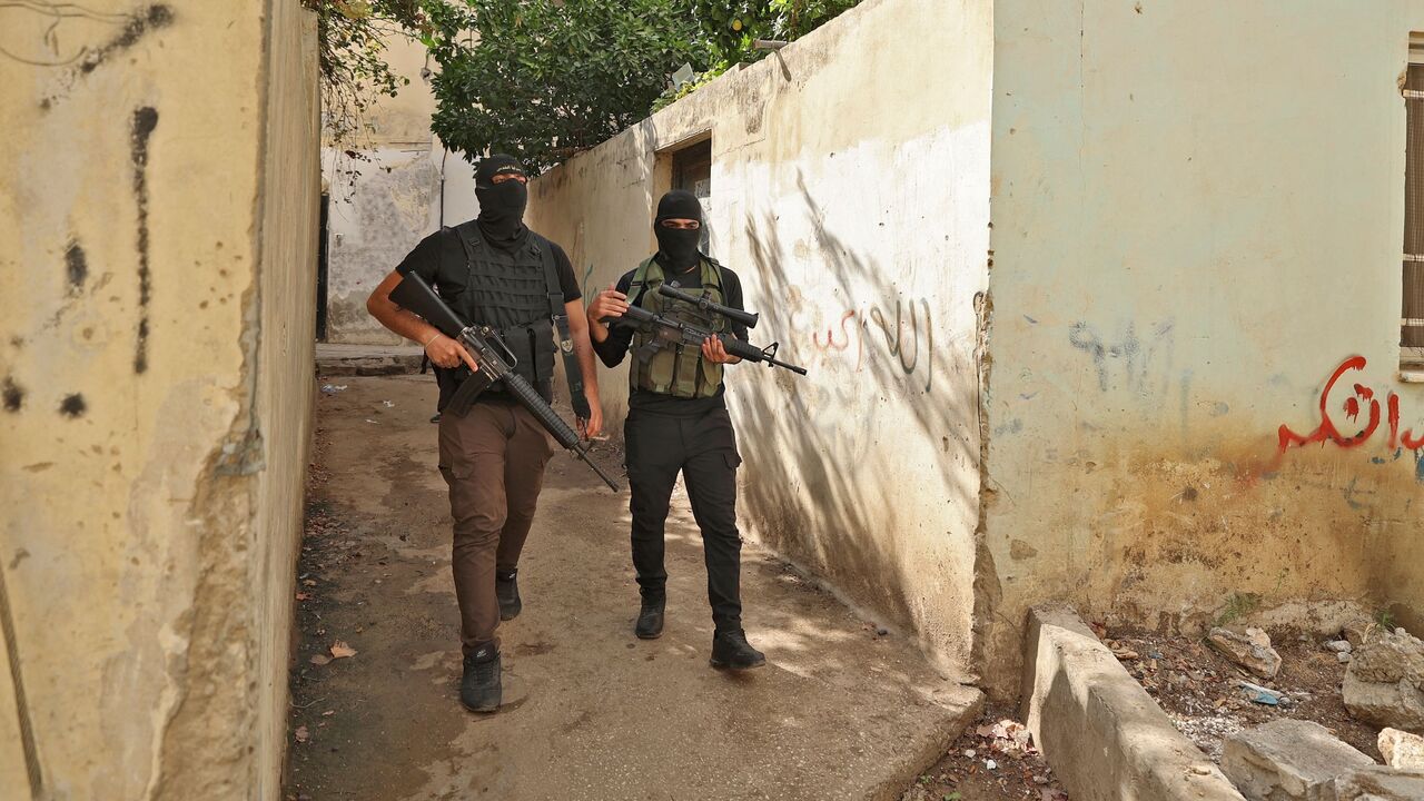 Members of the Saraya al-Quds walked through alleyways during the funeral of Mateen Debaya, killed during an Israeli raid, in the Jenin refugee camp, near the West Bank city of the same name, in the occupied West Bank, on Oct. 14, 2022.