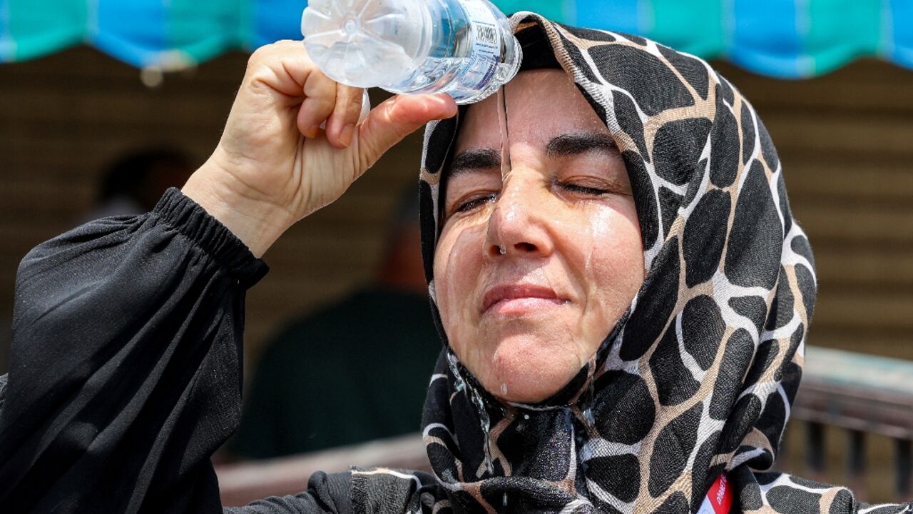 A Turkish pilgrim pours cold water on her head to cool off in Saudi Arabia's holy city of Mecca