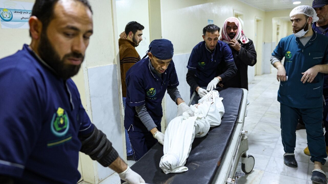 The body of a victim in the Syrian civil war is carried away at the hospital in Idlib