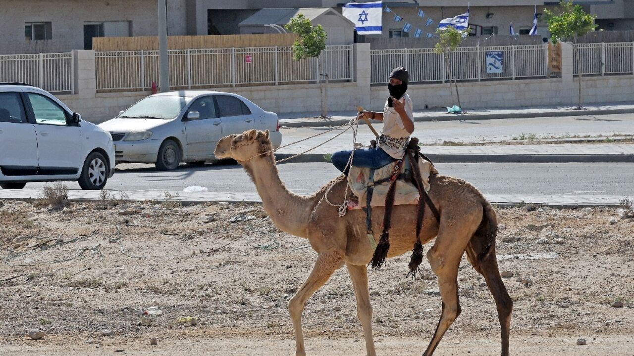 A youth rides a camel at the unrecognised Bedouin village of Ras Jrabah, close to a neighbourhood of Dimona city in southern Israel