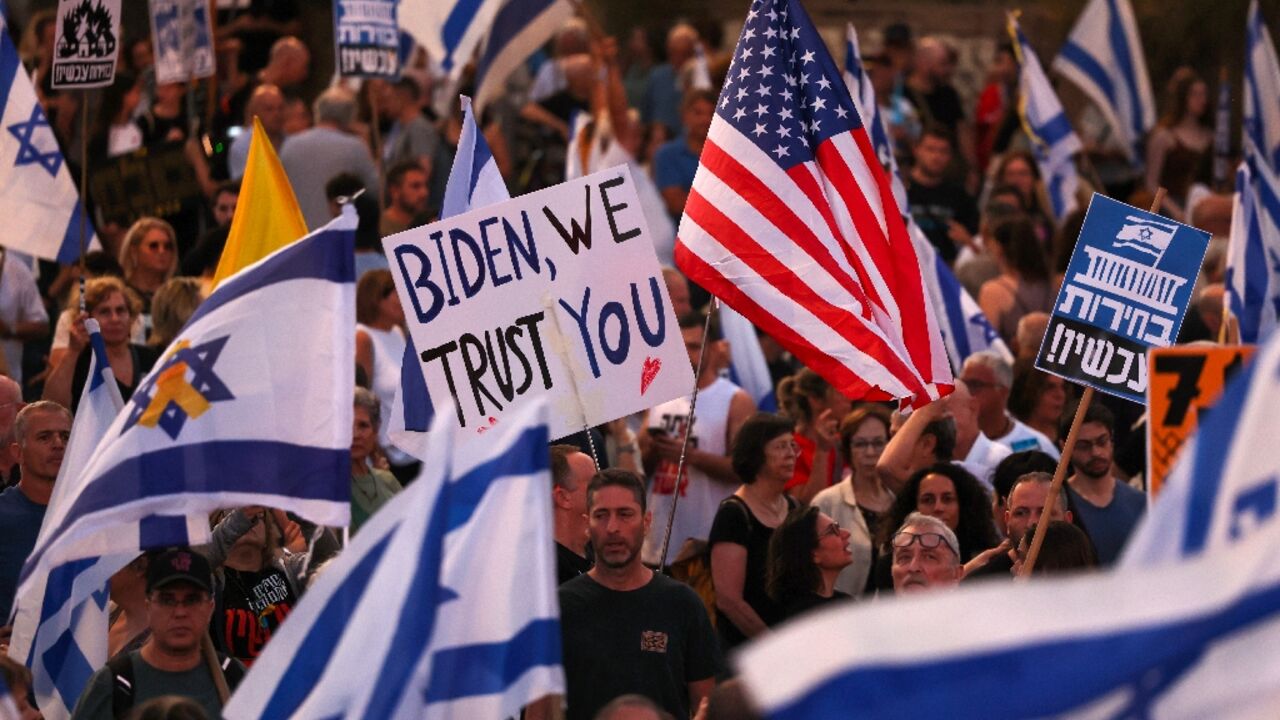 Israeli demonstrators wave the Stars and Stripes alongside the national flag as they press the hard-right government not to disavow a ceasefire plan set out by President Joe Biden