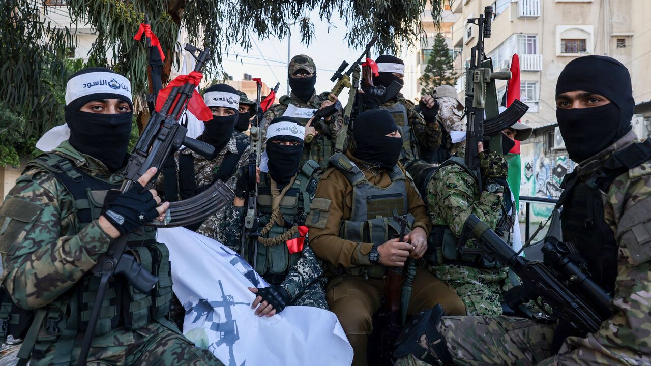 Palestinians Hamas militants wearing headbands reading in Arabic "the Lion's Den", in reference to the Nablus based Lion's Den armed group, march in support of the group in Gaza City on Dec. 10, 2022. 