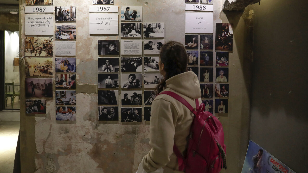 A visitor looks at portraits of late Franco-Lebanese film director Maroun Baghdadi and pictures from his movies at the venue of an exhibition dedicated to his memory in Beirut on December 12, 2023, as Lebanon commemorates the 30th annivesary of his death in an accident at the age of 43. (Photo by ANWAR AMRO / AFP) (Photo by ANWAR AMRO/AFP via Getty Images)