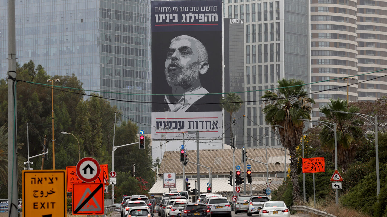 Cars drive past a billboard bearing an inscription in Hebrew which reads 'think well of who benefits from our division - unity now', with a portrait of the head of the political wing of the Palestinian Hamas movement in the Gaza Strip Yahya Sinwar, in Tel Aviv on April 26, 2024, amid the ongoing conflict between Israel and the Palestinian militant group Hamas in the Palestinian territory. (Photo by JACK GUEZ / AFP) (Photo by JACK GUEZ/AFP via Getty Images)