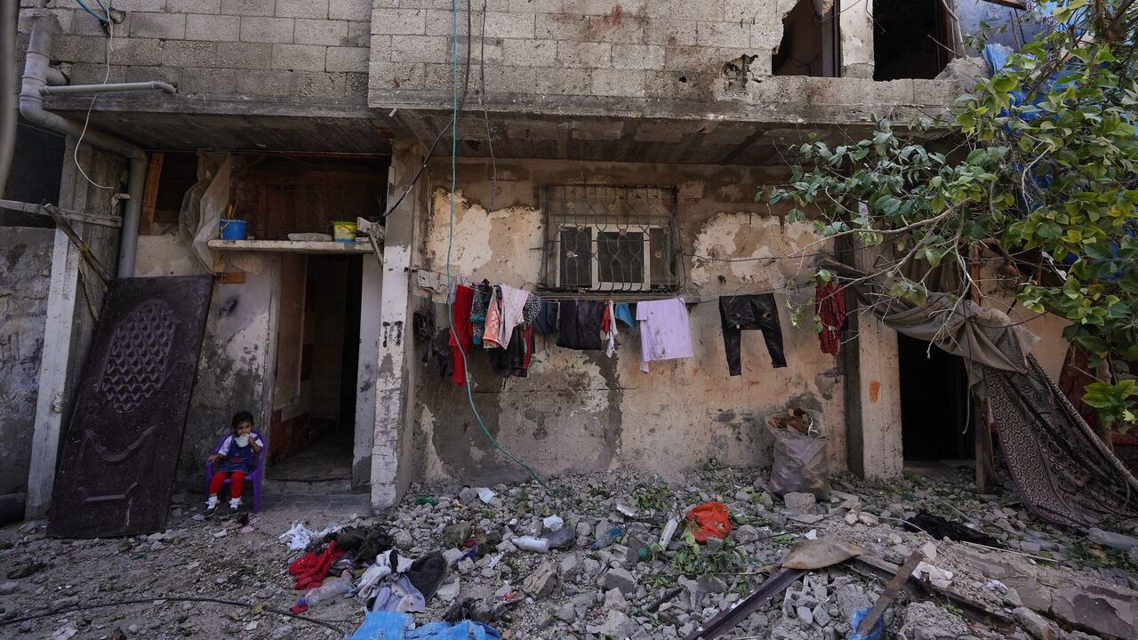 A Palestinian girl sits next to rubble from the Al-Rai family home which was hit at dawn in Israeli bombardment of Nuseirat city in the central Gaza Strip on June 18, 2024, amid the ongoing conflict between Israel and the Palestinian militant Hamas movement. 