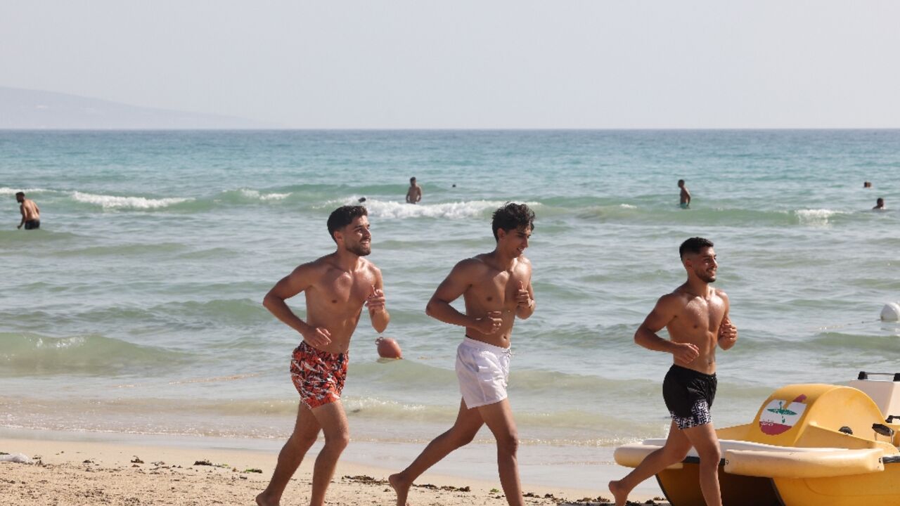 People spend the day on the beach in the port city of Tyre in southern Lebanon despite fears of war with Israel amid near-daily clashes between Hezbollah and Israeli forces