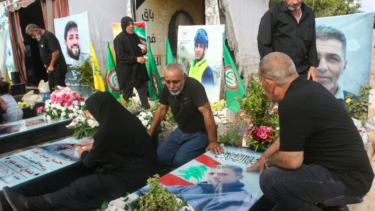 Relatives visit the graves of killed Hezbollah fighters during Eid al-Adha in the southern Lebanese town of Naqura