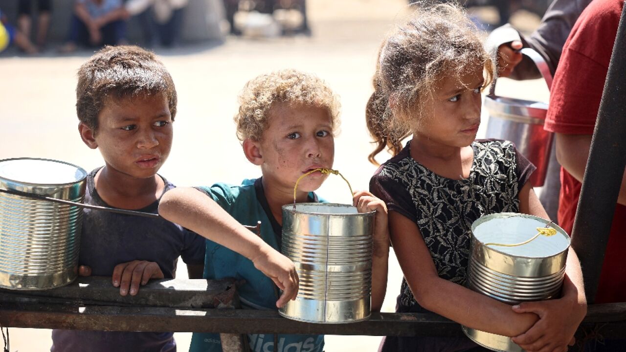 Displaced children wait for food being distributed in Khan Yunis, southern Gaza -- the World Health Organization said more than 8,000 children aged under five have been treated for acute malnutrition in Gaza