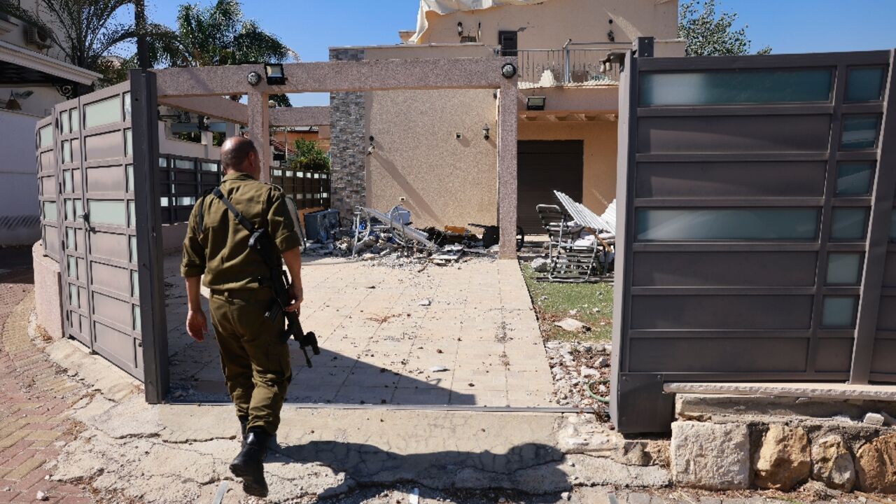 An Israeli soldier checks a house that was hit by a Hezbollah rocket in Kiryat Shmona, northern Israel, near the Lebanon border