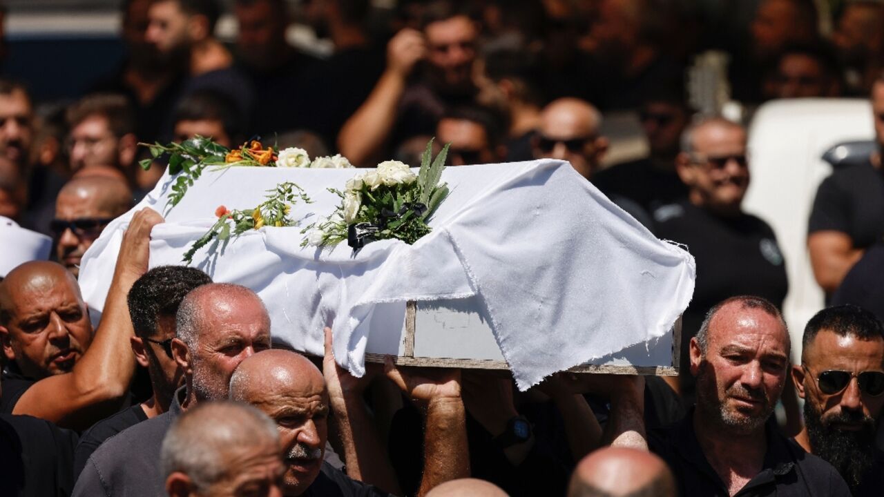 Druze pallbearers carry the coffin of Guevara Ibrahim, 11, one of 12 children killed in a rocket strike in the Druze Arab town of Majdal Shams in the Israeli-annexed Golan Heights on Saturday