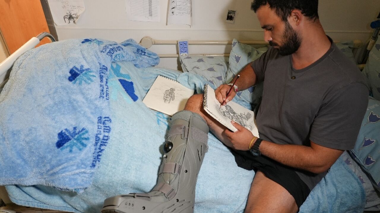 Barak, whose leg was shredded by a grenade during a hostage rescue mission in Gaza, draws as he sits on his bed at the Ichilov hospital in Tel Aviv