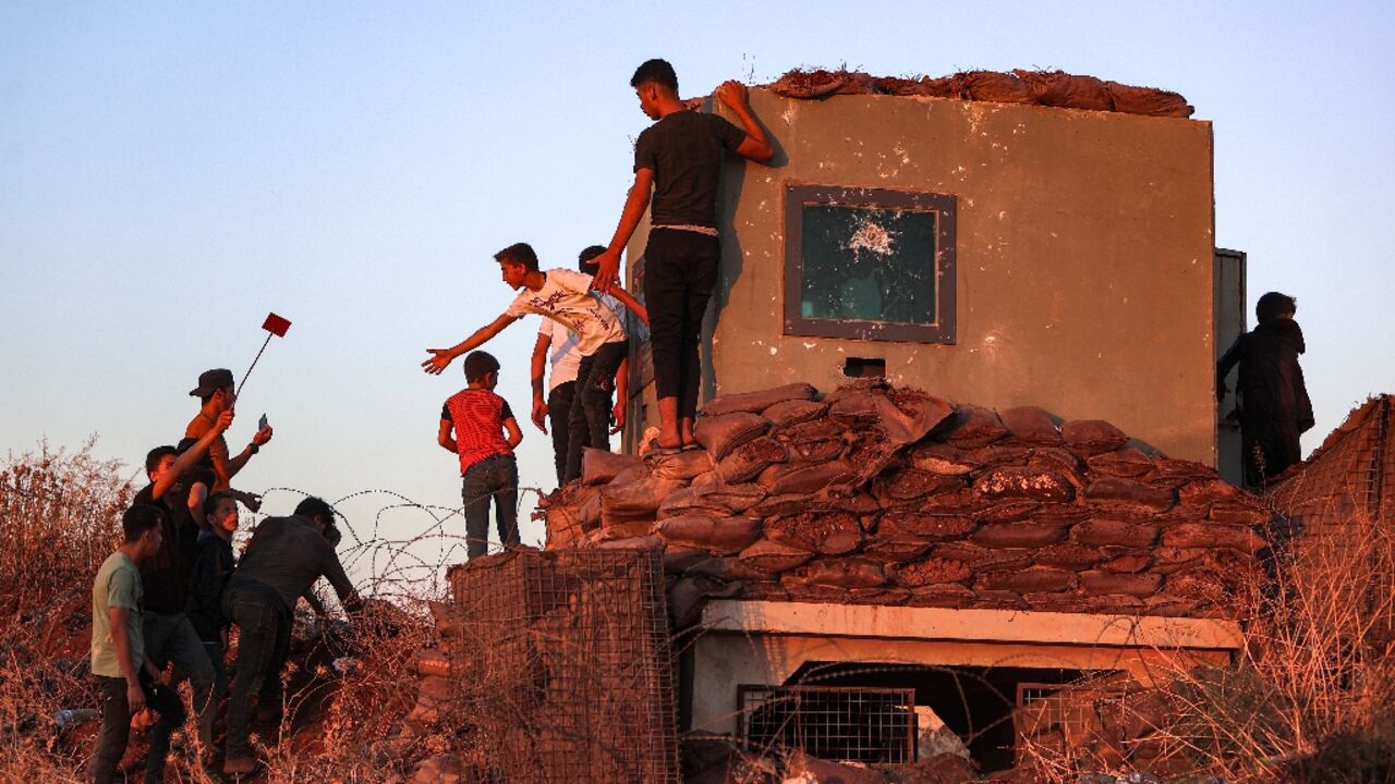 Syrian demonstrators vandalise a Turkish army observation point during a protest in Ibbin Samaan in northern Syria