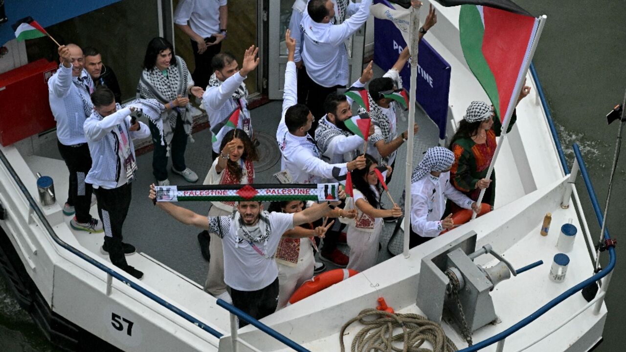 Abu Sel can be seen holding the flag as the Palestinian delegation sailed up the Seine during the opening ceremony 
