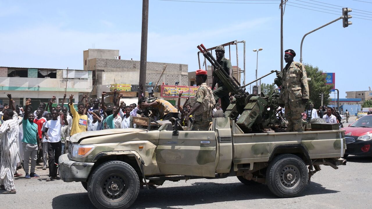 Sudanese greet army soldiers, loyal to army chief Abdel Fattah al-Burhan, in the Red Sea city of Port Sudan on April 16, 2023. 