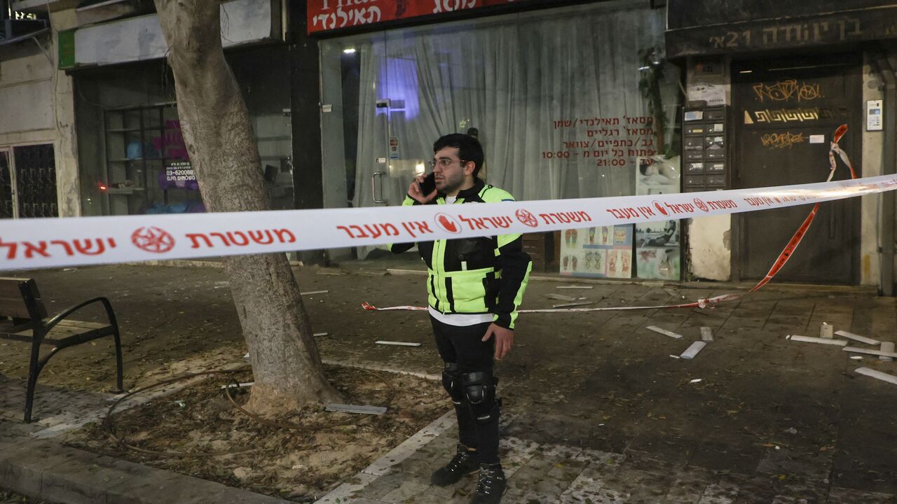 An Israeli policeman makes a phone call on the scene where an explosion took place in Tel Aviv on July 19, 2024.