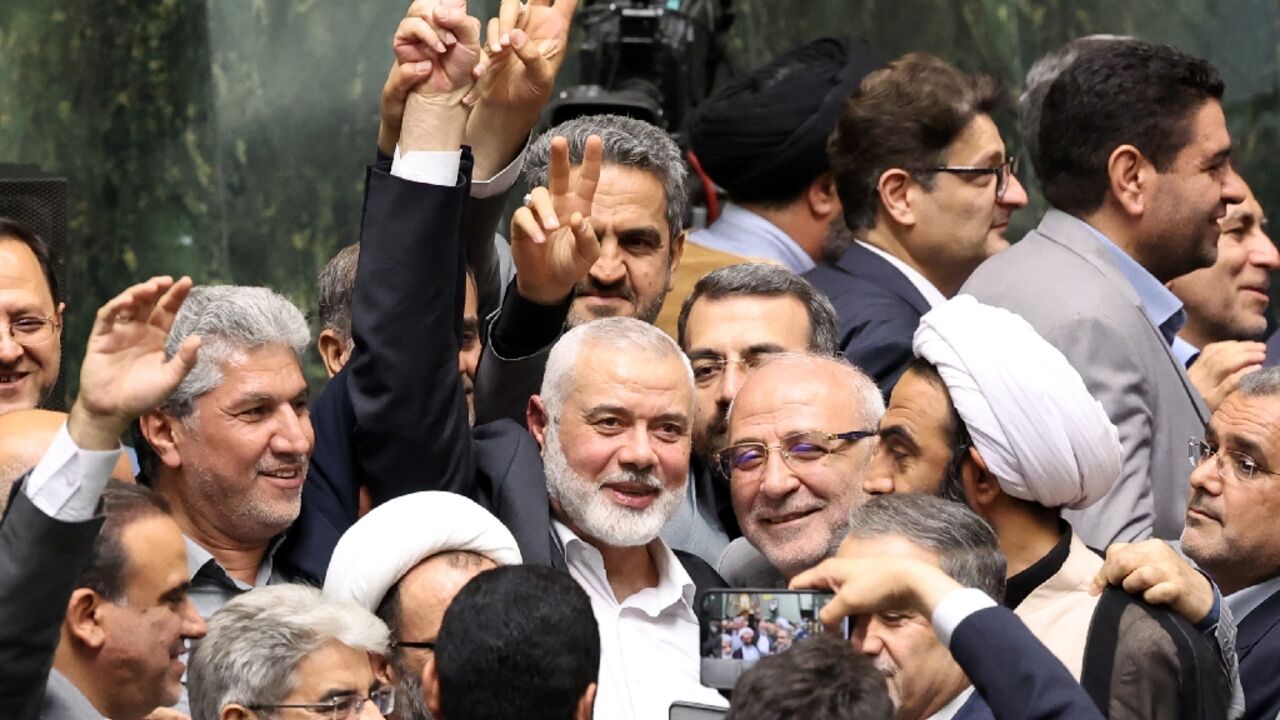 Hamas political leader Ismail Haniyeh flashes a victory sign during the swearing-in of Iranian President Masoud Pezeshkian hours before his death in an air strike in Tehran