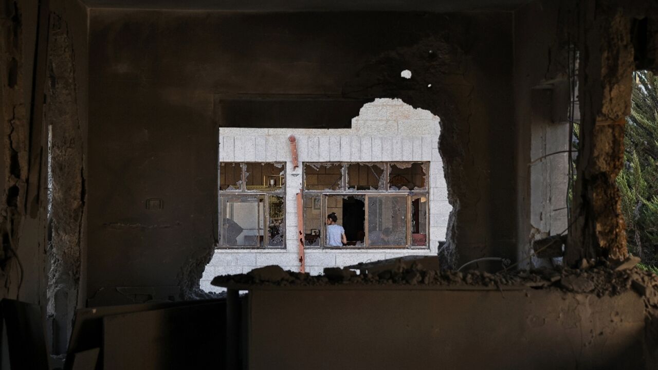 Palestinians inspect the damage after Israeli troops demolish the home of detained suspect Khaled Kharouf in the West Bank city of Ramallah