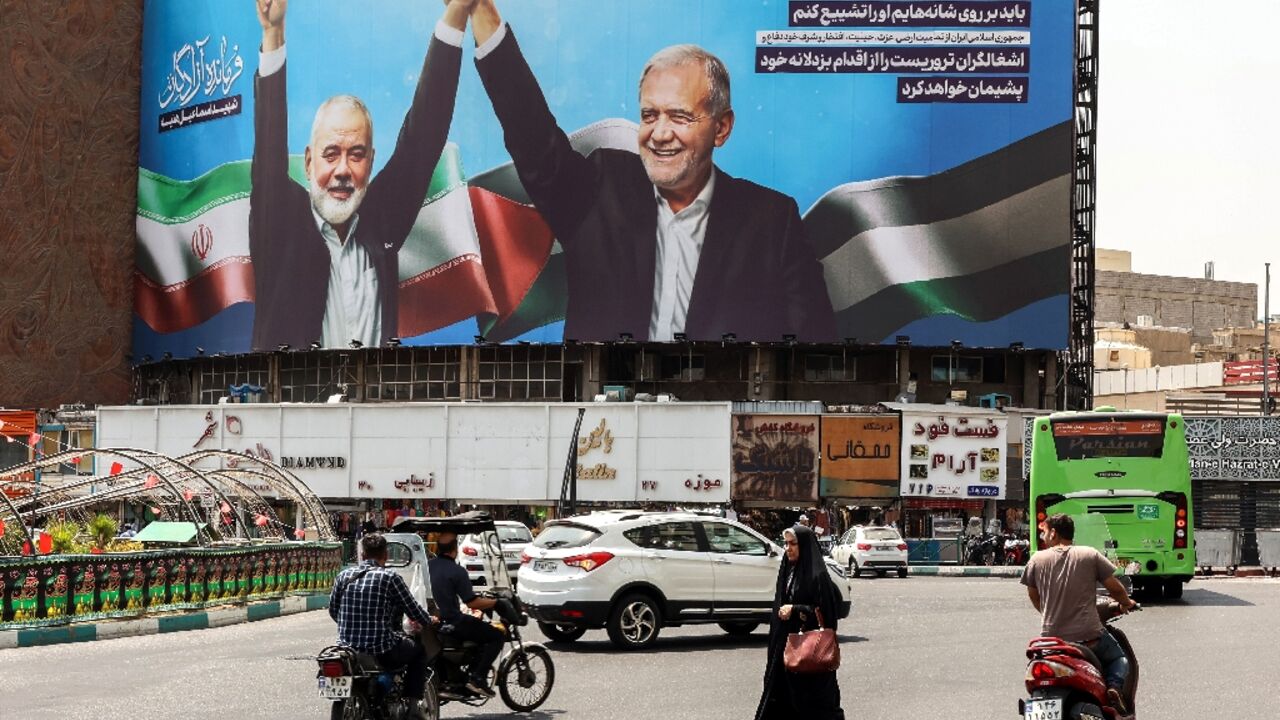 A billboard in Tehran showing Iranian President Masoud Pezeshkian (R) and late Hamas leader Ismail Haniyeh