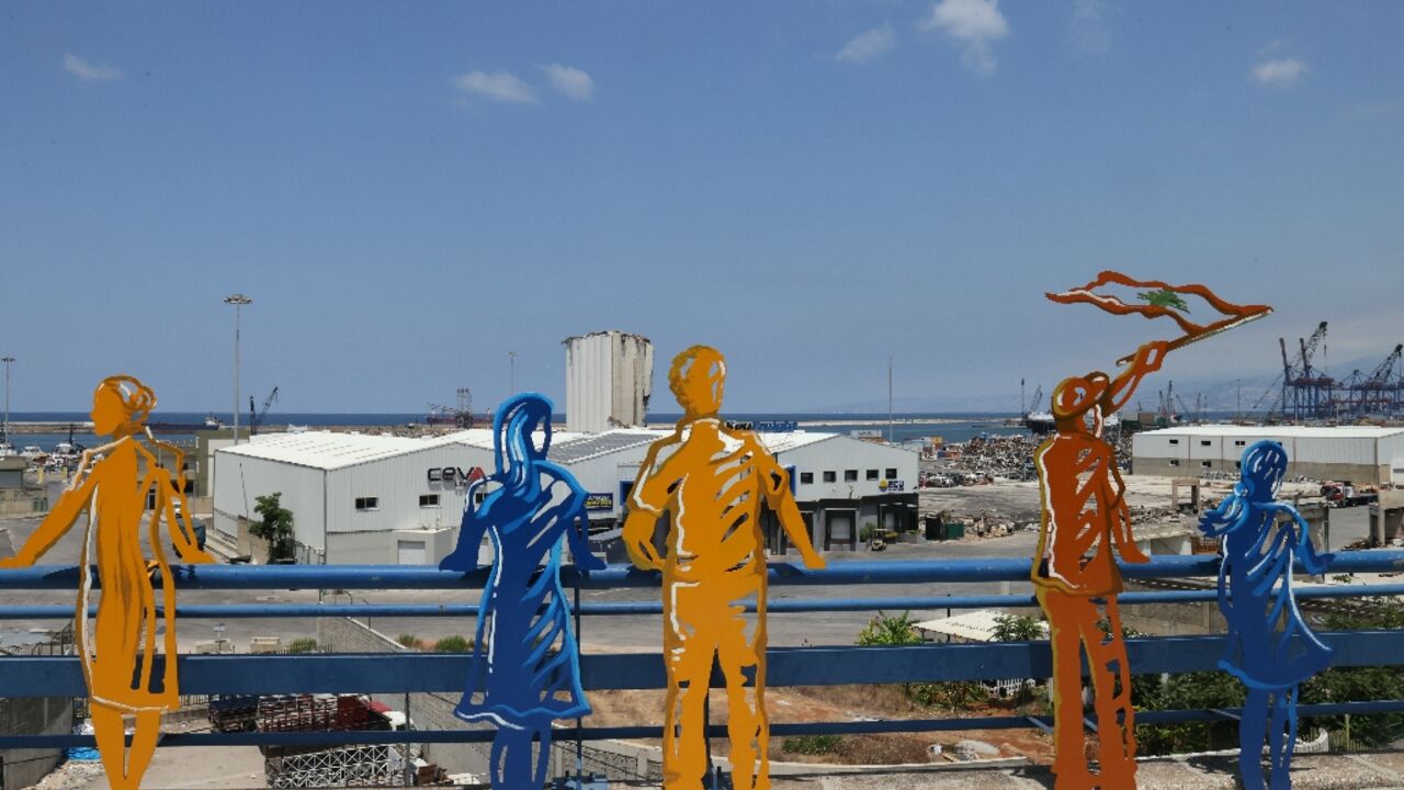 Sculpted figures representing people staring at the devastation are lined up along the road overlooking Beirut's port,  four years after a catastrophic explosion there that killed more than 220 people