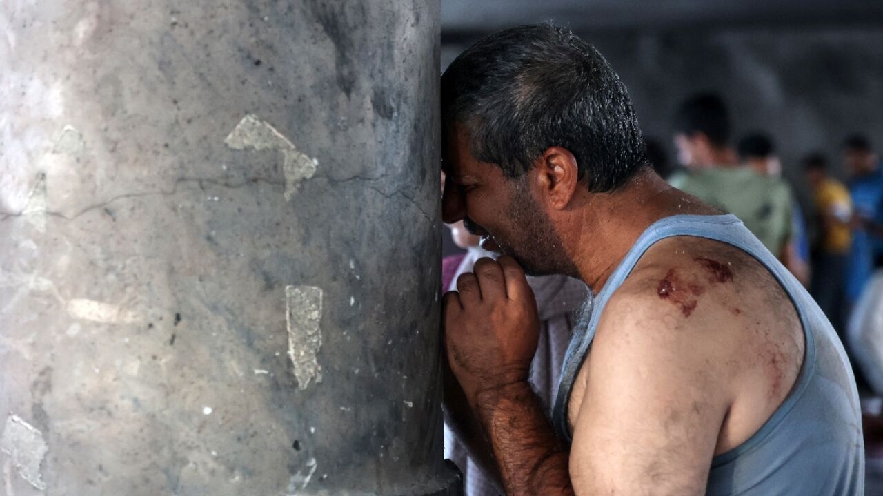 A man cries inside a school used as a temporary shelter for displaced Palestinians in Gaza City, after a deadly Israeli strike 