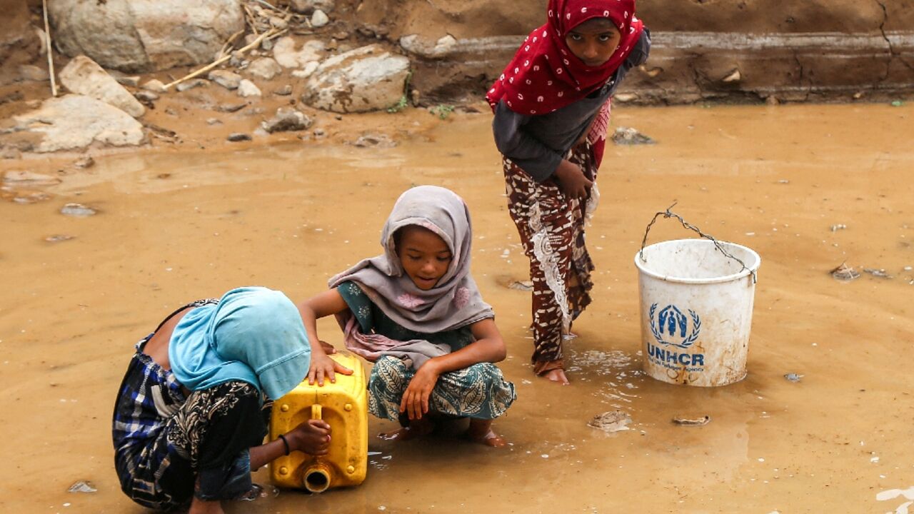 Yemeni children fill a jerrycan with water after flash floods in Hodeida province on the Red Sea coast.