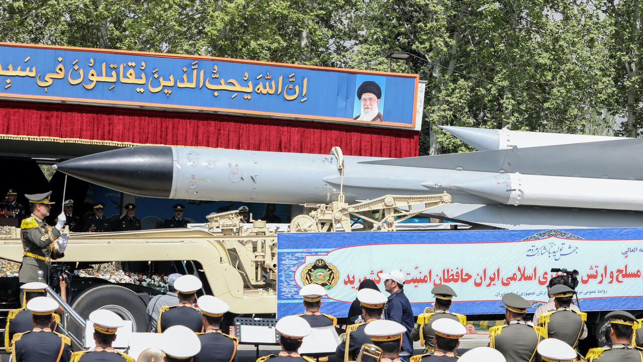 A member of the Iranian armed forces conducts an army orchestra as a truck carries a missile during a military parade as part of a ceremony marking the country's annual army day in Tehran on April 17, 2024. 